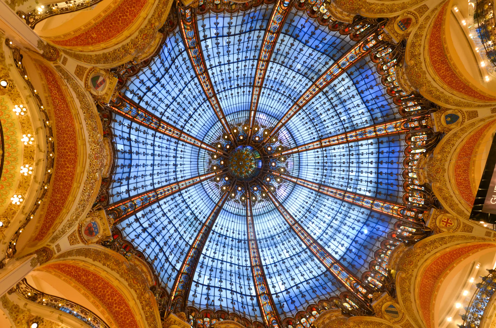 Cúpula de vitrais azuis e dourados das Galeries Lafayette, em Paris, vista de baixo