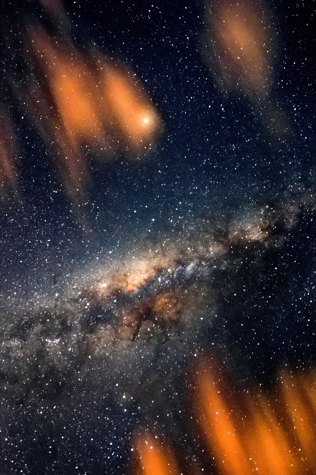 Via Láctea com o centro galáctico no céu estrelado de Boipeba, com nuvens alaranjadas nos cantos